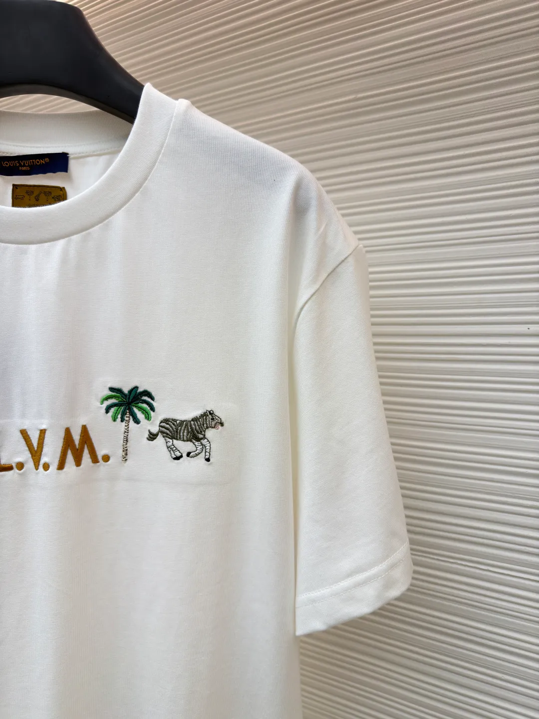 LOUIS VUITTON animal embroidery short-sleeved T-shirt ●Original version: Purchased and developed at 9350 ●Item number: 1682215-A05 ●Fabric: cotton fabric ●Technology: embroidery production ●Color: white ●Version: fitted version ●Weight: about 260 grams ●Size: XS-S-M-L ●Description: This embroidered short-sleeved T-shirt is made of high-end clothing technology. The fabric is made of 260g heavy-weight mercerized cotton. It has been treated with liquid ammonia mercerization to give the cotton a delicate luster. It is also anti-wrinkle and breathable, and its skin-friendliness and drape are greatly improved. The theme pattern on the chest adopts embroidery technology that combines Su embroidery flat stitch and seed embroidery. The animal and plant patterns show three-dimensional texture through different stitching methods. The letters are filled in with embroidery technology. The stitch density reaches 8 stitches per centimeter. The colors are full and the lines are neat. The embroidery edges are overlocked to avoid fuzzing. The neckline is reinforced with three needles and is paired with high-density rib fabric to keep it from loosening after long-term wear. The side seams of the body are seamlessly heat-pressed to reduce friction when worn. The overall style adopts a loose cut with slightly dropped shoulders, combined with three-dimensional cutting technology, which not only ensures wearing comfort, but also modifies the body line. The overall wiring is straight and delicate, the fabric is comfortable and soft, and the color is consistent without color difference. It can be matched with the same style to create a fashionable look and control various occasions. Customized accessories, complete with three standards, same style for men and women!